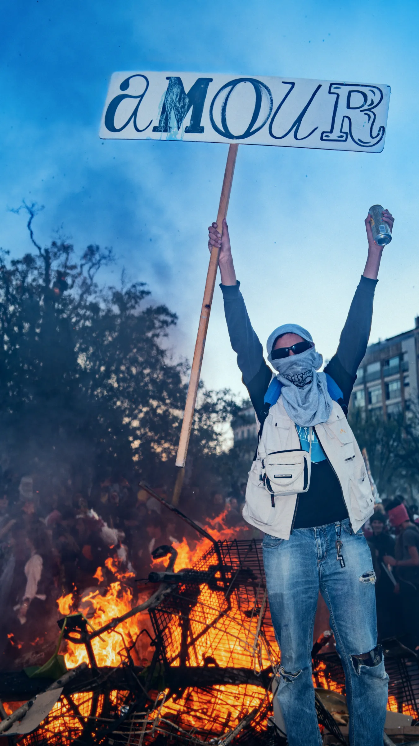 A man seen from behind, standing before the burning Caramantran effigy at Marseille's Carnaval de la Plaine 2026.