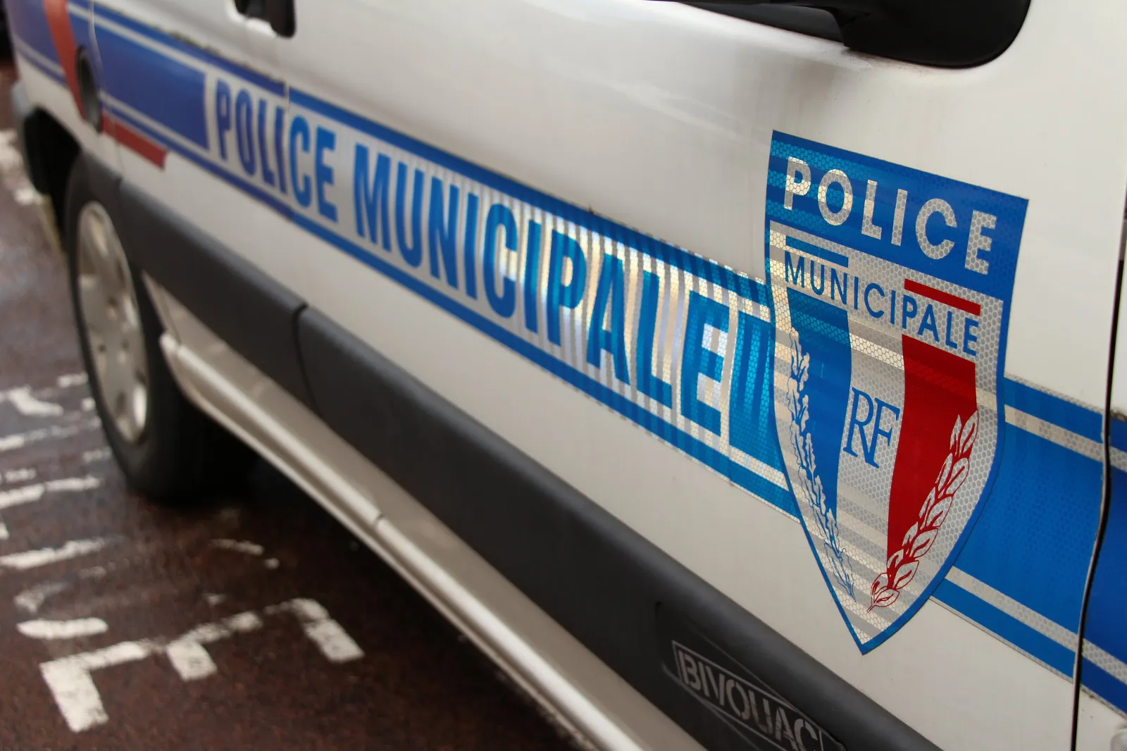 Véhicule de police municipale avec le logo et les inscriptions visibles sur la carrosserie.